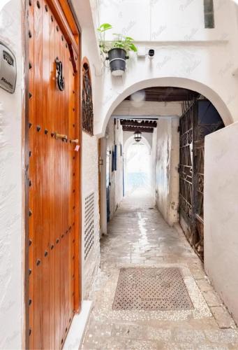 an alleyway in an old building with a wooden door at Studio M in Tangier