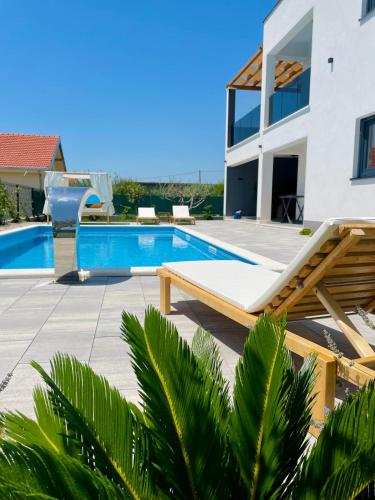 a villa with a swimming pool and a house at Villa C'est la vie in Kaštela