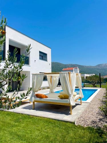 a villa with a swimming pool and two lounge chairs at Villa C'est la vie in Kaštela