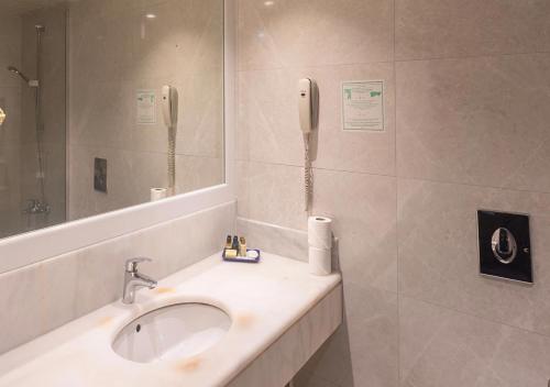 a bathroom with a sink and a phone at Özkaymak Incekum Resort - Ultra All Inclusive in Avsallar