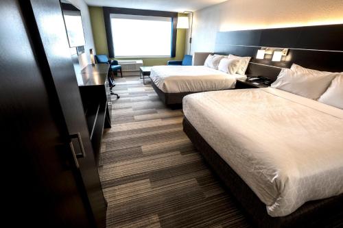 a hotel room with two beds and a desk at Holiday Inn Express & Suites - Commerce by IHG in Commerce
