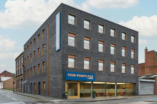a black brick building with a four points takeaway sign on it at Four Points Flex by Sheraton Birmingham Jewellery Quarter in Birmingham