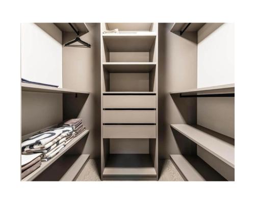 a walk in closet with white cabinets and shelves at Zuhause am Bodensee in Bottighofen