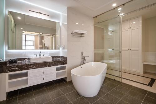 a bathroom with a tub and a large mirror at Tao Dan Hotel in Ho Chi Minh City