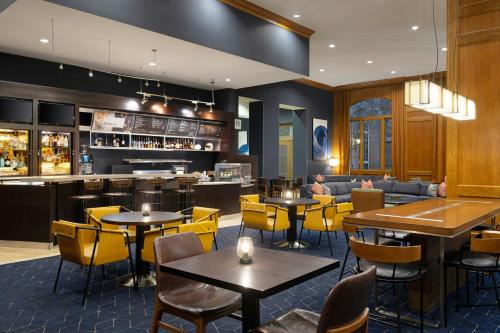 a restaurant with tables and chairs and a bar at Courtyard by Marriott Nashville Green Hills in Nashville