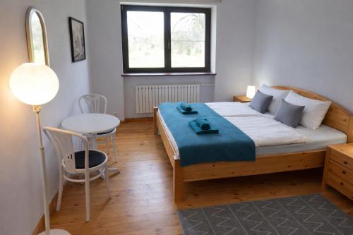 a bedroom with a bed and a table and a chair at Pensjonat Kowalski in Łubowo