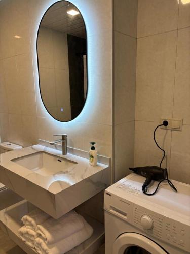 a bathroom with a sink and a washing machine at Alvina 29 in Tsaghkadzor