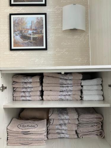 a shelf filled with towels in a bathroom at Vila Palas in Vrnjačka Banja