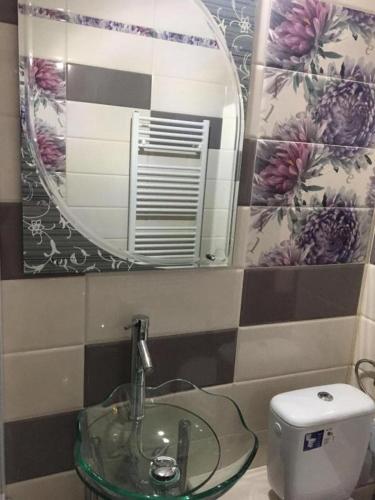 a bathroom with a sink and a mirror and a toilet at KM 0 one RESIDENCE in Piatra Neamţ