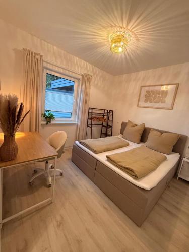 a bedroom with a bed and a table and a window at Gemütliches Apartment in Kehl am Rhein