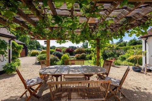 a patio with a table and chairs under a pergola at Orchard Paddocks in Guildford