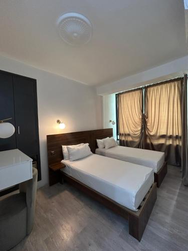 ein Hotelzimmer mit zwei Betten und einem Fenster in der Unterkunft Crystal in Tangier