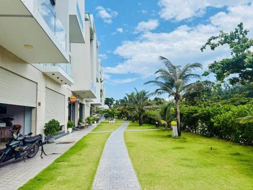 a walkway in front of a building with green grass at New Day Tuy Hòa in Liên Trì (4)