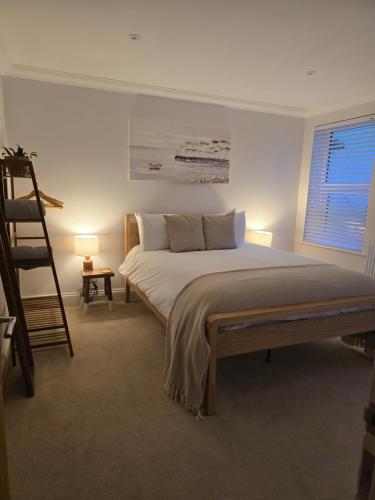 a bedroom with a large bed and a ladder at Luxury, Spacious 3 Bedroom, Beachfront Apt with Parking & Courtyard - Shoreside in Margate