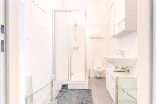 a white bathroom with a sink and a toilet at Stadtwohnung im Zentrum in Größing