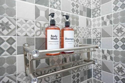 two bottles of soap on a shelf in a bathroom at Omah Ninten Syariah Laweyan RedPartner in Solo