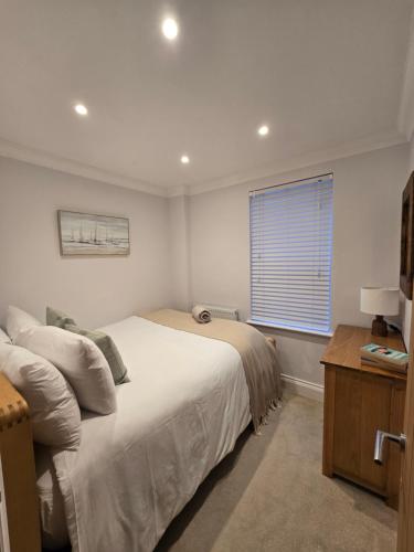 a bedroom with a large bed and a window at Luxury, Spacious 3 Bedroom, Beachfront Apt with Parking & Courtyard - Shoreside in Margate