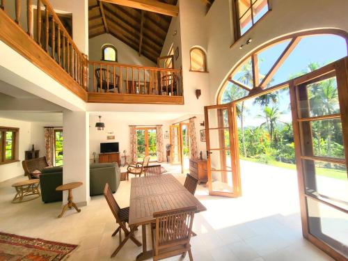 an open living room with a table and chairs at Luxury Cannelle lake villa in Hikkaduwa