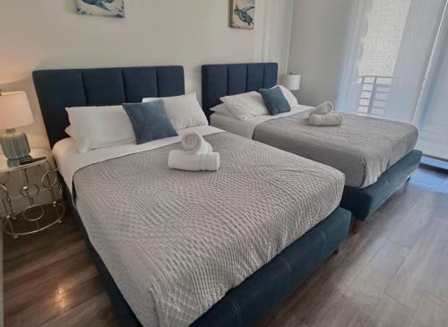 two beds with towels on them in a bedroom at Beachside Luxury Apartment I Free Parking in Los Angeles