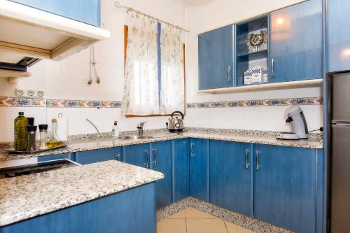 a blue and white kitchen with blue cabinets at Villa Capital Mountainview in Carboneras