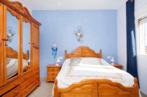 a bedroom with a wooden bed and a wooden cabinet at Villa Capital Mountainview in Carboneras