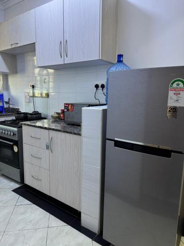 a kitchen with a stainless steel refrigerator and a stove at Luxx Homes #Unit A in Ruiru