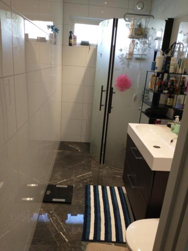 a bathroom with a shower and a toilet and a sink at Villa Bliss in Surte