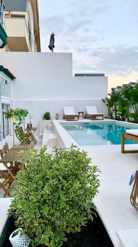 a pool with chairs and a table and a building at Villa Rafa in Costa Nova