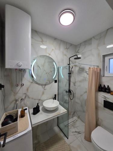 a bathroom with a glass shower and a sink at Sotto Il Sole in Surčin