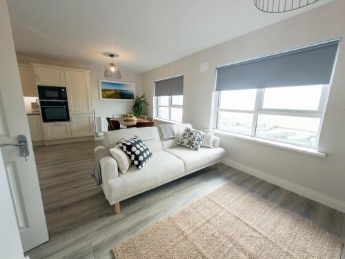 a living room with a couch and a large window at Luxury 2-Bedroom Apartment Overlooking the Beach in Bundoran
