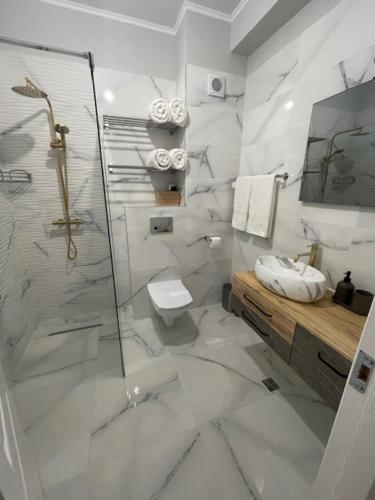a white bathroom with a shower and a toilet at VCV Apartments in Mamaia Sat/Năvodari