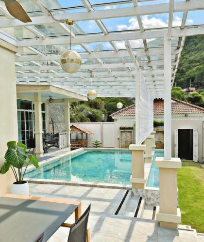 a swimming pool in a house with a pergola at Kamala Beach Phuket - 4BR Private Luxury Pool Villa with Maid in Kamala Beach