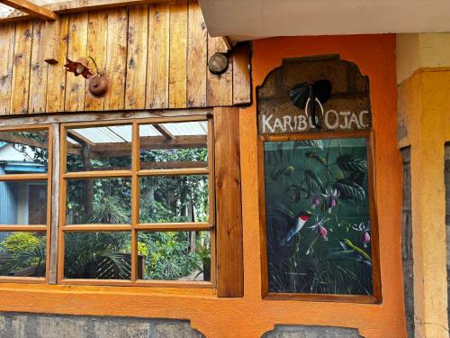 a building with two windows and a sign on it at Ojac Guesthouse in Iten
