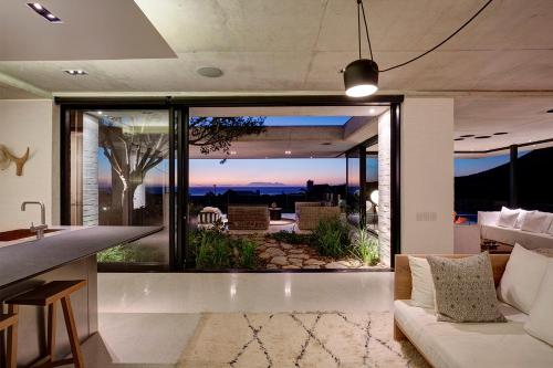 a living room with a view of the ocean at Restio River House in Pringle Bay