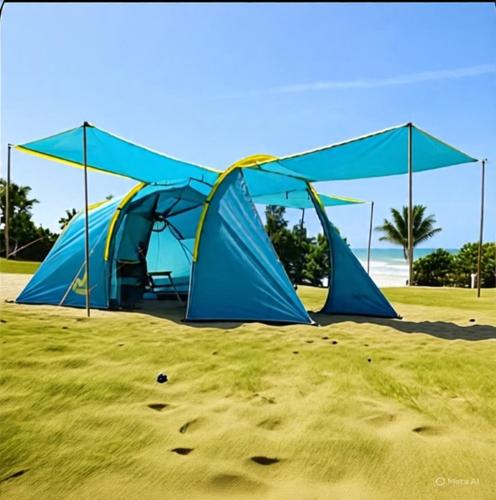 a group of tents in the sand on a beach at Tenda Premium Pantai Madasari in Bulakbenda