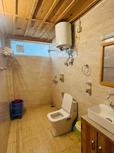a bathroom with a toilet and a sink at Shivalik Resorts in Barkot