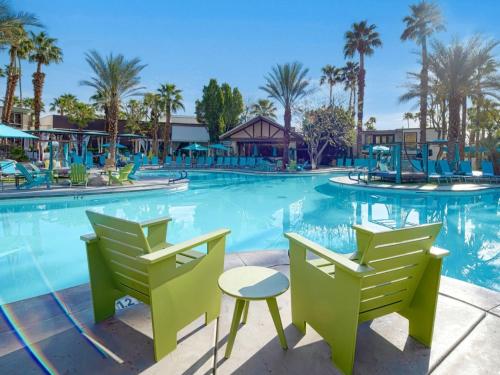 a pool at the resort with chairs and tables at Riviera Resort Palm Springs in Palm Springs