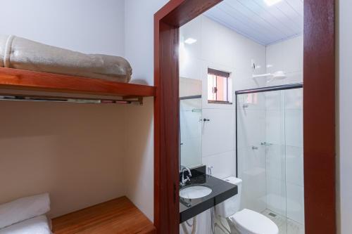 a bathroom with a toilet and a sink and a shower at Pousada Pouso Vitoria in Pirenópolis