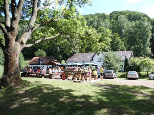 a group of people sitting at tables under a tree at Green Valley Park in Stárkov
