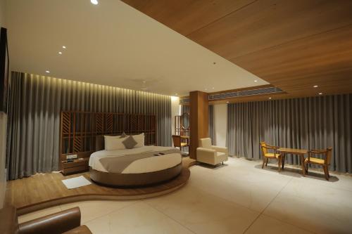 a bedroom with a bed and a desk and a table at SUNDHA HOTEL palanpur in Pālanpur
