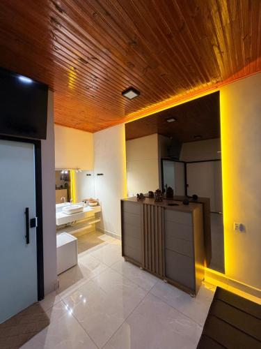 a large kitchen with a wooden ceiling and a counter at Hotel KK 1021 in Coxim