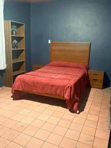 a bedroom with a bed with a red bedspread at Ohmen House in Guadalajara