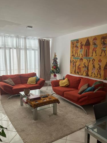un soggiorno con due divani rossi e un albero di Natale di AkyaSpot a Praia