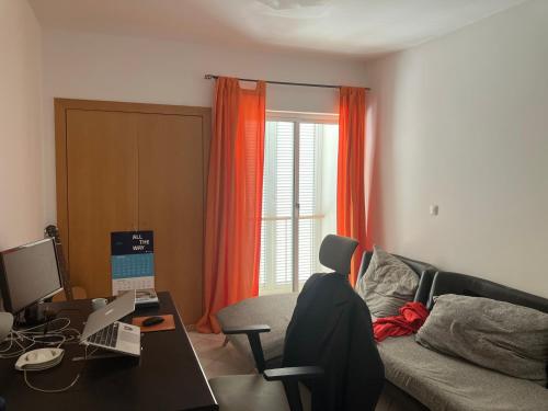un soggiorno con una scrivania con un computer sopra di AkyaSpot a Praia