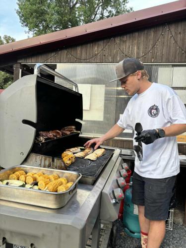 a man is cooking donuts on a grill at Camp Litomerice in Litoměřice