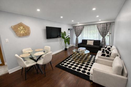 a living room with a couch and a table and chairs at Newly Renovated 3BR North York Bungalow with Backyard Patio & Volleyball Set! Close to Rogers Stadium, TTC Subway Access, Perfect for Family Travel, Group Trips & Work Stays! in Toronto