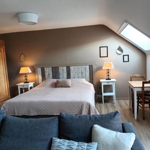 a bedroom with a bed and a couch at Le Relais De La Motte in Soignies