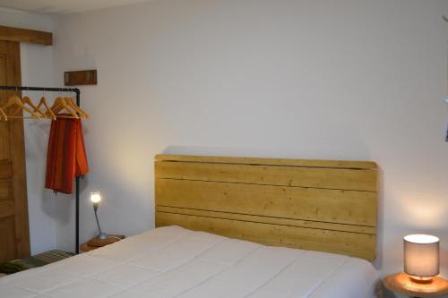 a bed with a wooden headboard in a bedroom at Casa Aurora in Escusa