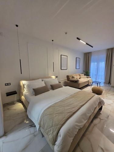 a large white bedroom with a large bed and a couch at Sotto Il Sole in Surčin