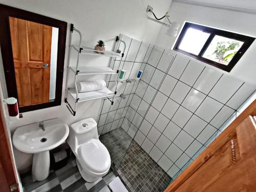 a small bathroom with a toilet and a sink at The Chicken House in El Castillo de La Fortuna
